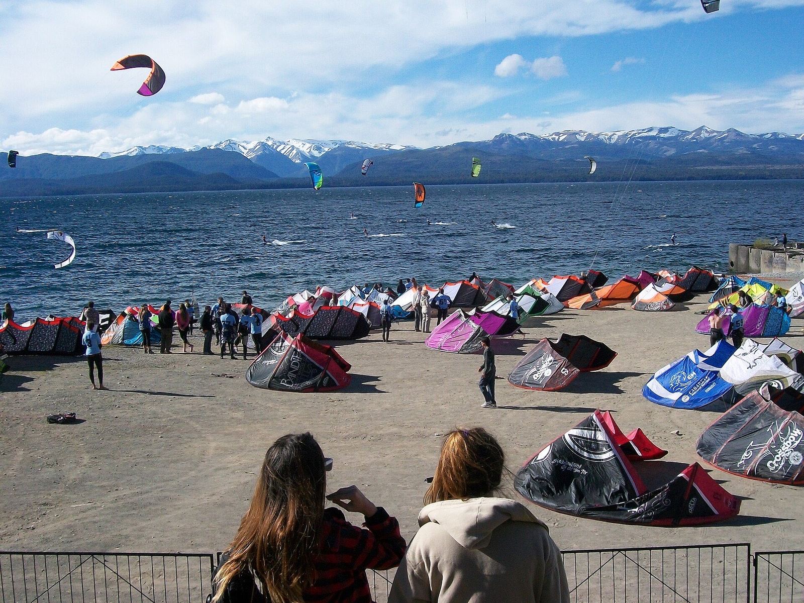 Cometas de colores listas en la orilla de un lago patagónico