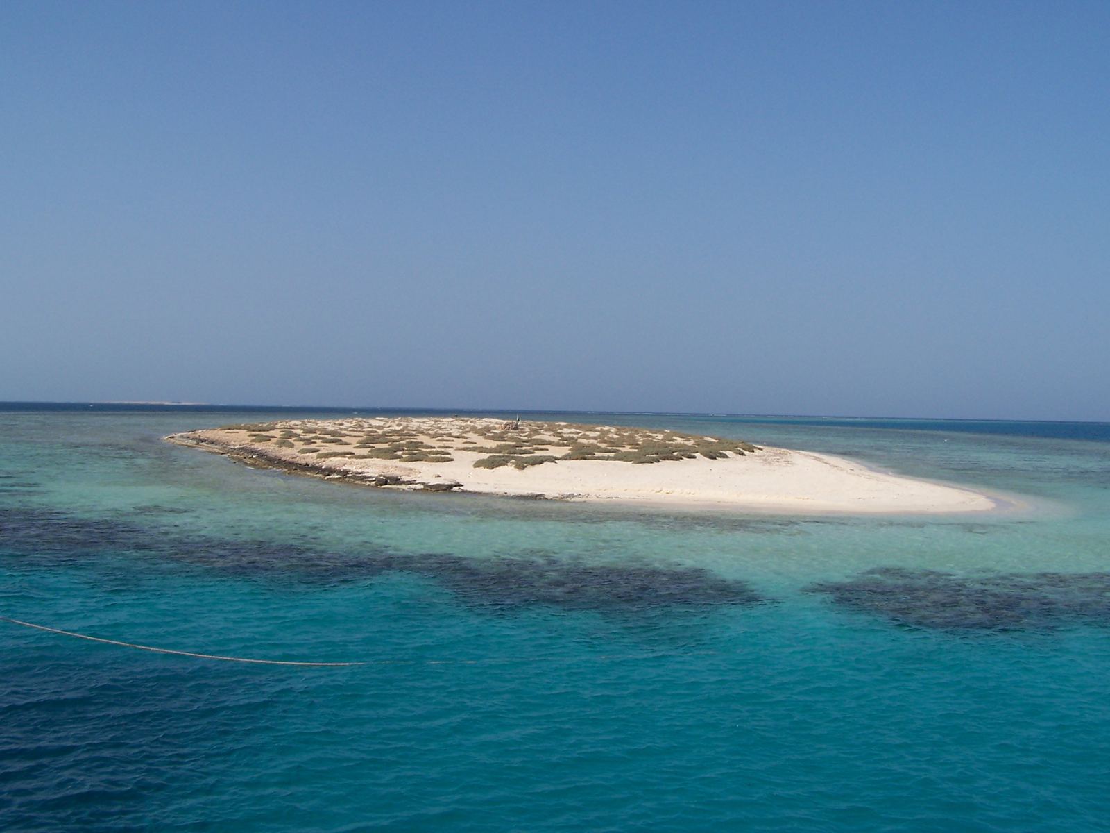 Isla baja de arena blanca rodeada de agua turquesa en el Mar Rojo